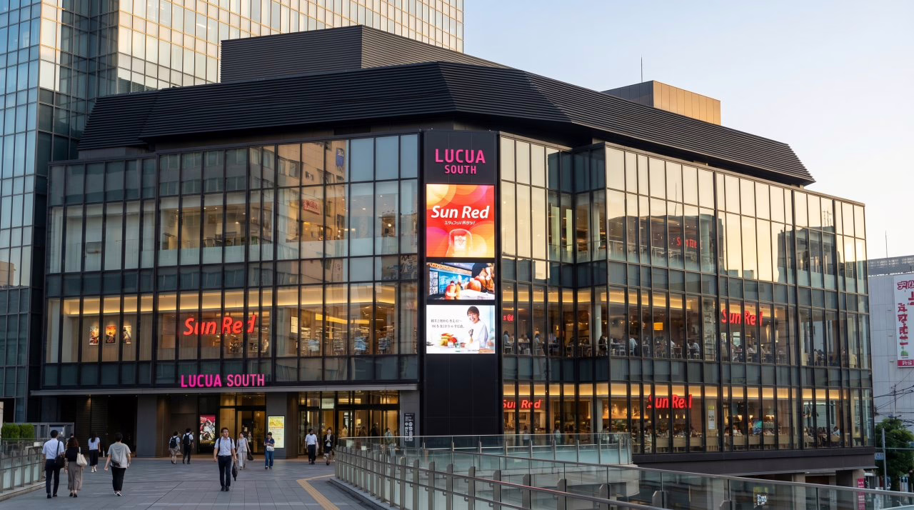 Modern commercial building Lucua South features vibrant signage and bustling pedestrians, showcasing a lively shopping experience.