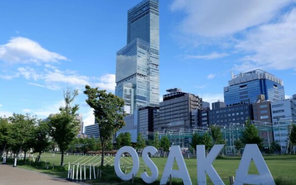 Osaka cityscape featuring skyscrapers and green park space, embodying urban vibrancy and modern architecture.