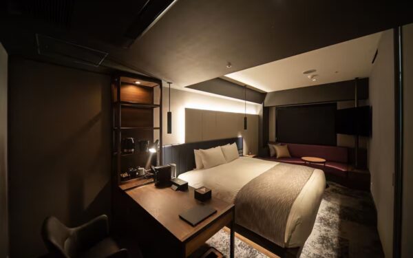 Modern hotel room showcasing a cozy bed and stylish workspace, perfect for travelers seeking comfort and convenience.