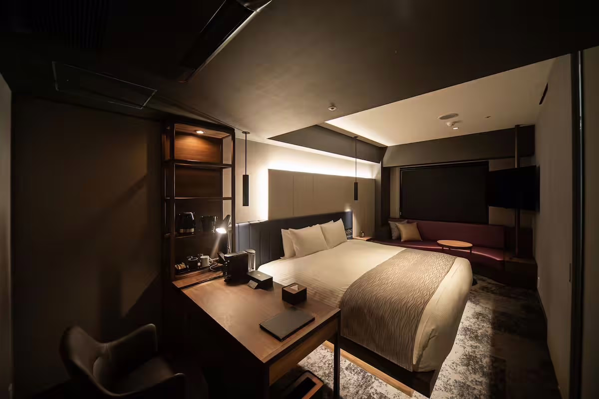 Modern hotel room showcasing a cozy bed and stylish workspace, perfect for travelers seeking comfort and convenience.