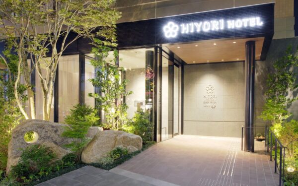 Elegant entrance of Hiyori Hotel, featuring a modern design with plants and illuminated paths for a welcoming atmosphere.