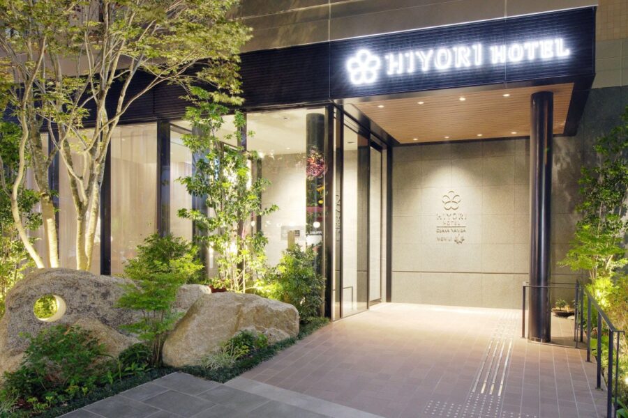 Elegant entrance of Hiyori Hotel, featuring a modern design with plants and illuminated paths for a welcoming atmosphere.