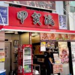Popular street food stall in Japan, featuring vibrant signage and a menu highlighting takoyaki and other local dishes.