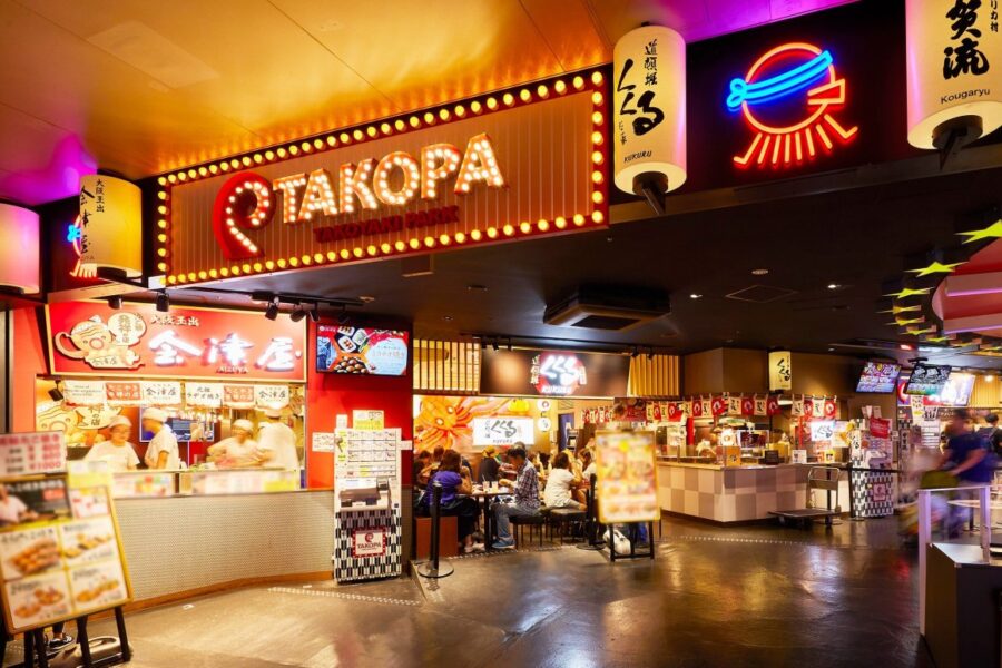 Vibrant Takoyaki Park showcasing various food stalls and diners enjoying Japanese street food in a lively setting.