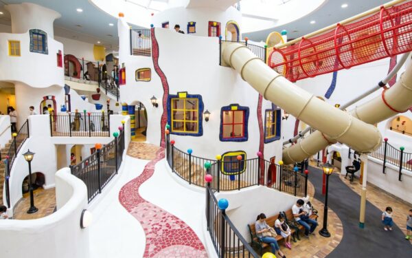 Kids Plaza Osaka: Colorful indoor playground featuring winding paths, slides, and playful architecture, designed for children's enjoyment and exploration.
