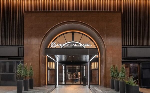 Modern entrance of Oriental Hotel, showcasing elegant design and inviting atmosphere for travelers seeking luxury accommodations.