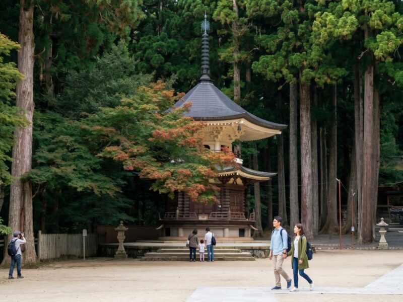 Visitors explore a serene temple surrounded by lush greenery, capturing the tranquil beauty of the natural landscape.